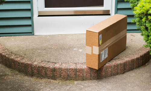 A cardboard box delivered at a front door of a home