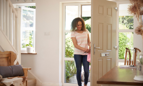 A woman opening the front door with keys